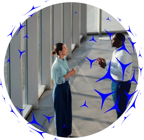 Imagem circular de pessoas conversando em um escritório moderno, sobreposta por ícones azuis em formato de aerogeradores.