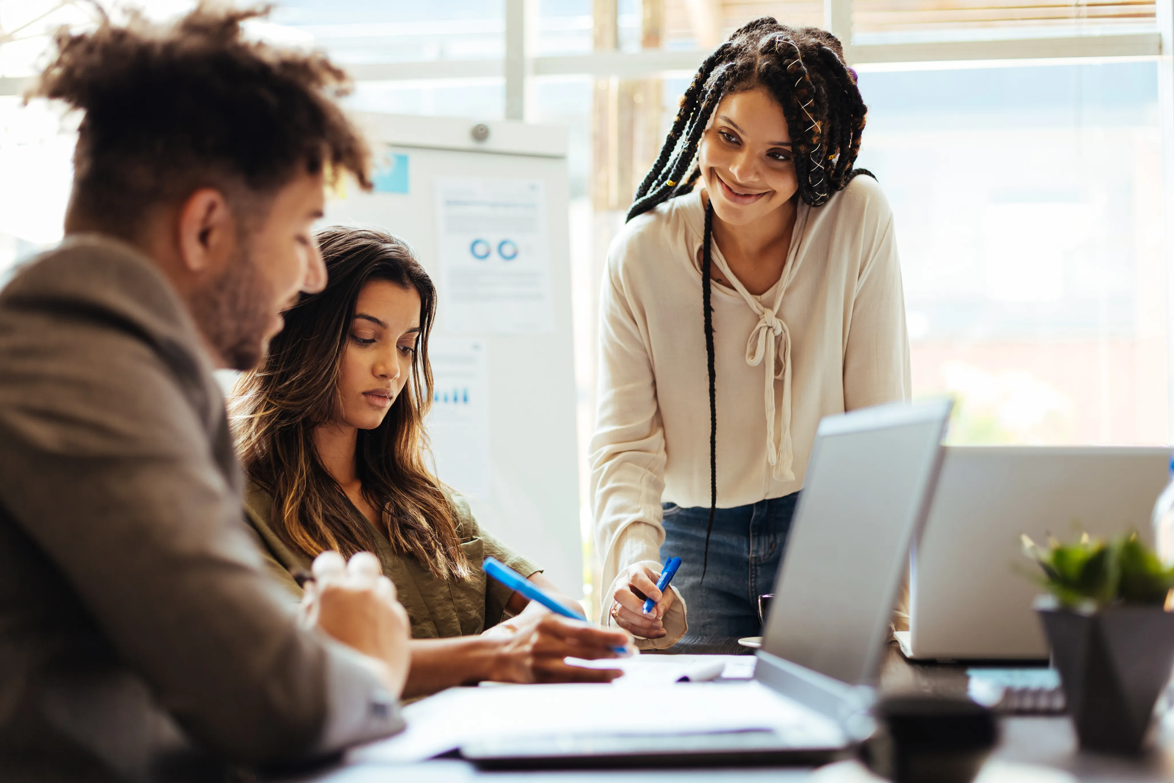 Três pessoas em um escritório debatendo uma ideia.