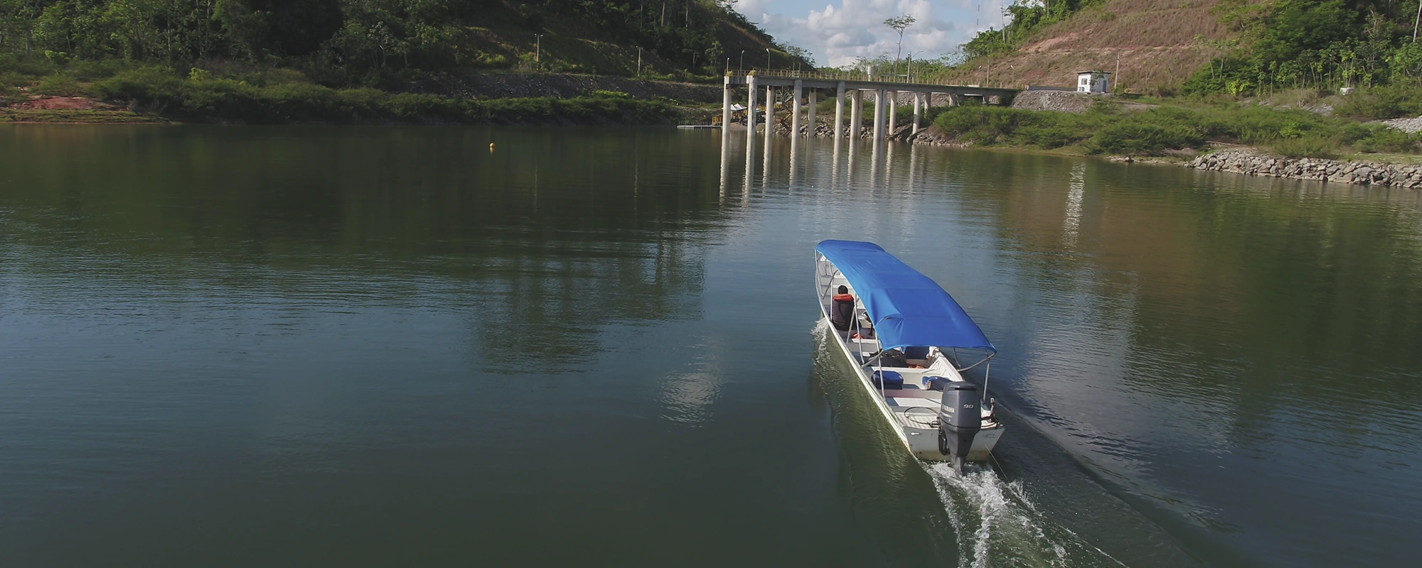 Embarcação navega em rio da UHE Pedra