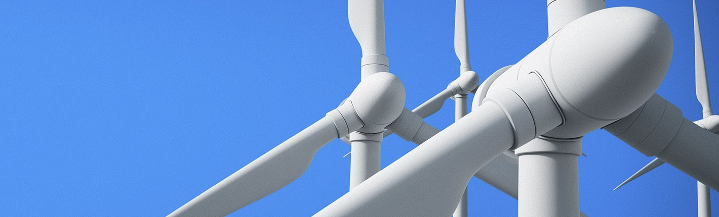 Close-up de turbinas eólicas brancas contra um céu azul claro.