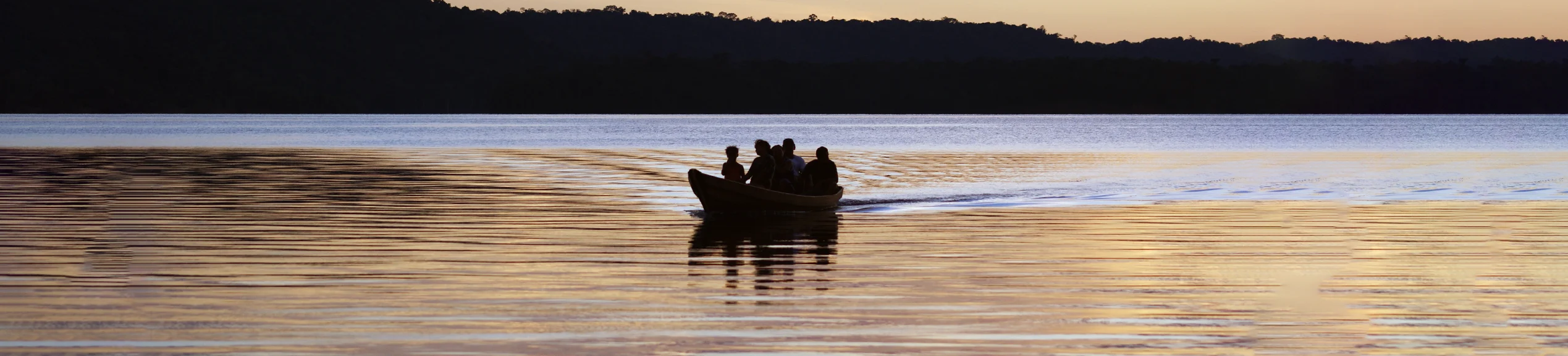 Barco com 5 pessoas em um rio