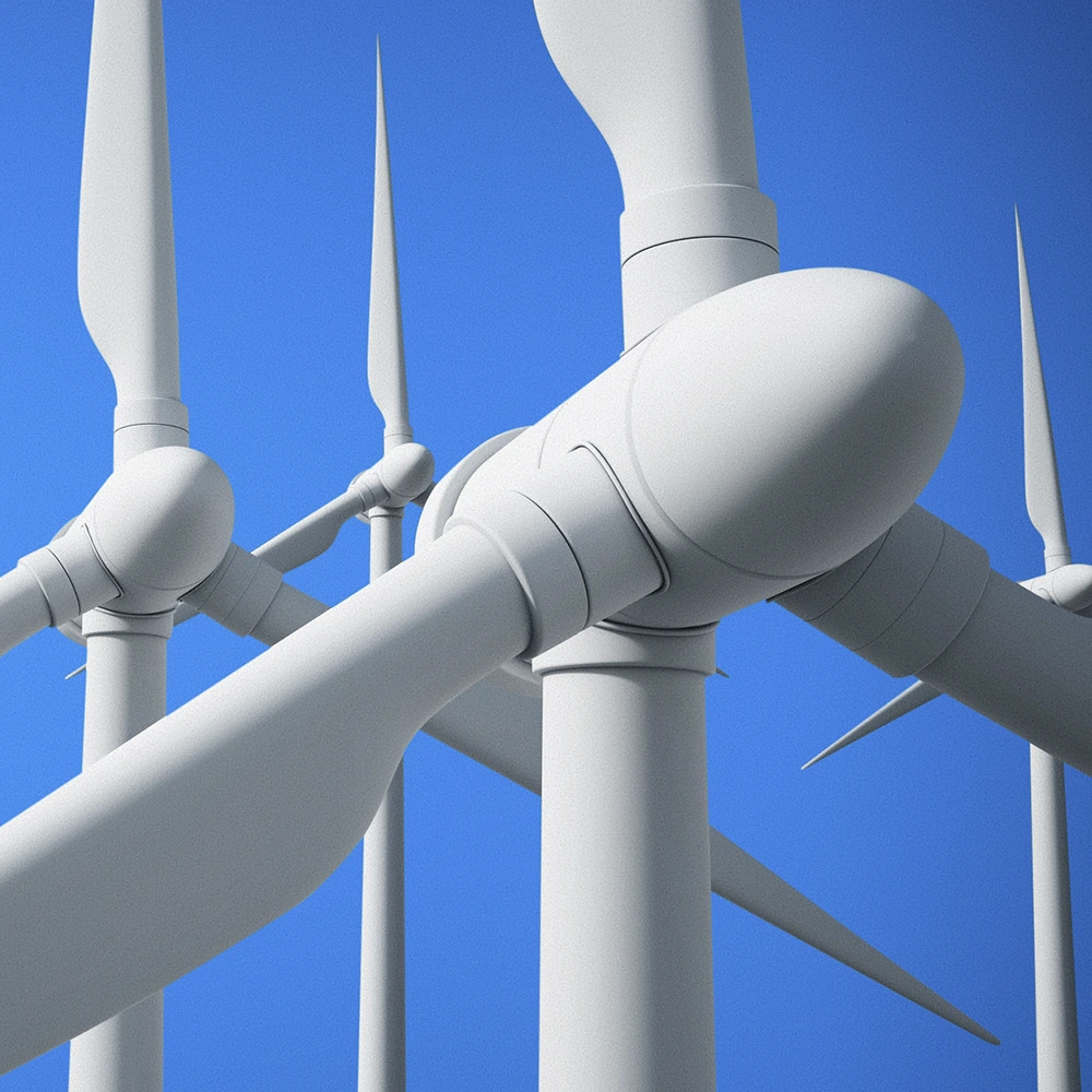 Close em aerogeradores de um parque eólico, com pás brancas em destaque contra o céu azul, representando a geração de energia renovável por meio dos ventos.