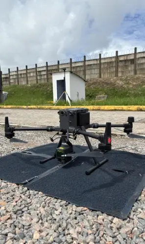 Drone com três hélices pousado em chão de pedras