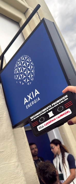 Placa do Prêmio Promoview recebida pela AXIA Energia em reconhecimento às iniciativas desenvolvidas durante o festival Rock in Rio 2026 , destacando a atuação da empresa em sustentabilidade e experiência de marca.