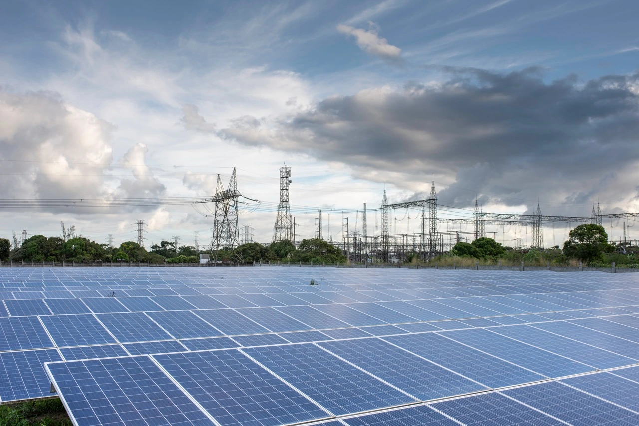 Usina energia solar com torres transmissão ao fundo